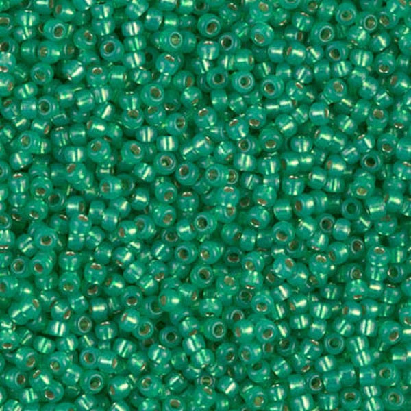Close-up of green glass beads with a metallic sheen.